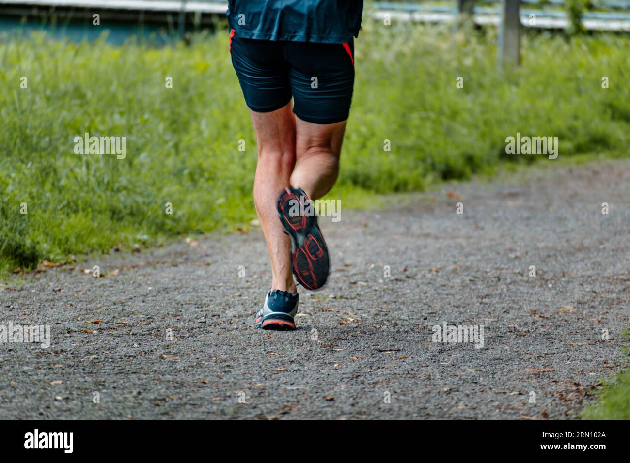 Uomo con scarpe da ginnastica che corre su un sentiero, attività di aiuto per fare sforzo Foto Stock