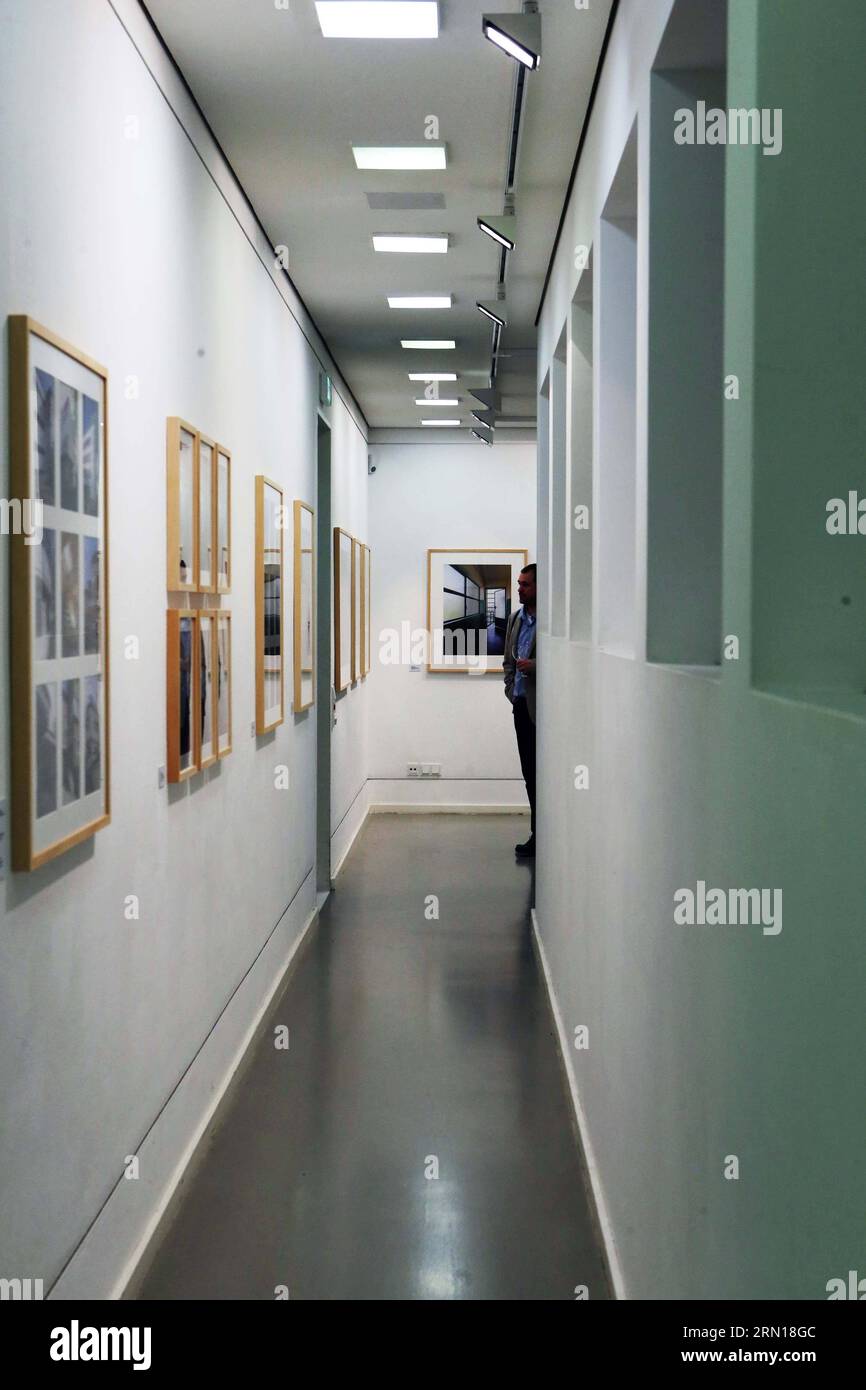 Un visitatore ammira le foto di Matthias Matzak durante la cerimonia di apertura della mostra LIGHT AIR SUN: The New Frankfurt in German Architecture Museum a Francoforte, Germania, il 05 dicembre 2014. Tra il 1925 e il 1930 la città di Francoforte si trasformò in un punto di riferimento del movimento New Building all'avanguardia, che conquistò l'intero continente europeo. Al centro di questa tendenza c'era lo sforzo di costruire alloggi sociali. Nel 2008 l'artista fotografico di Francoforte Matthias Matzak ha iniziato a registrare i resti di questa eredità con la sua fotocamera. Ha optato per un approccio soggettivo all'architettura, quindi dipingendo Foto Stock
