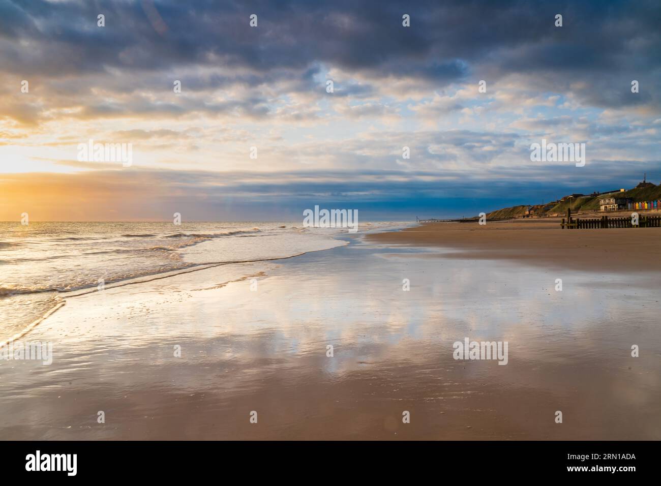 Marea che si ritira in una spiaggia vuota a Mundesley, North Norfolk Regno Unito all'alba Foto Stock