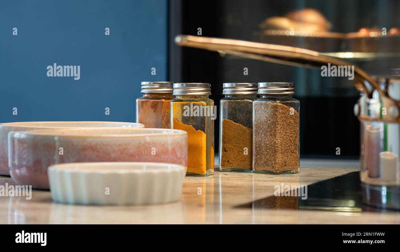 primo piano della natura morta in cucina durante la cucina casalinga, ciotole, pentola e spezie con forno in sottofondo come chef, cibo sano, concetto fatto in casa Foto Stock