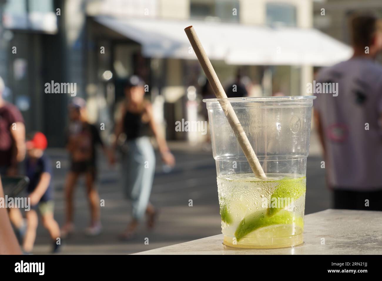 Bicchiere di plastica con mojito drink e pezzi di lime. Foto Stock