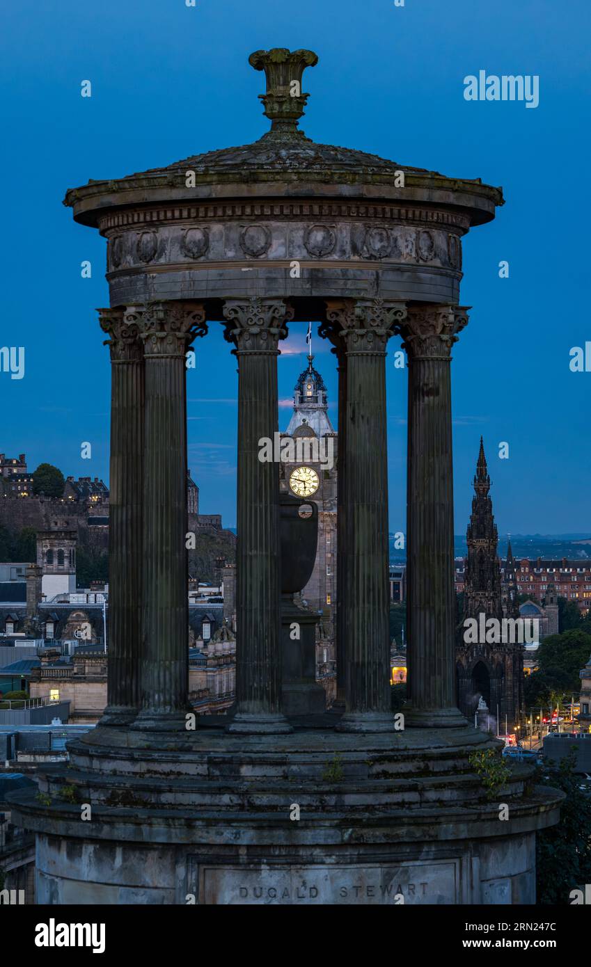 Torre dell'orologio Balmoral vista attraverso il monumento di Dugald Stewart in Blue Hour, Calton Hill, Edimburgo, Scozia, Regno Unito Foto Stock