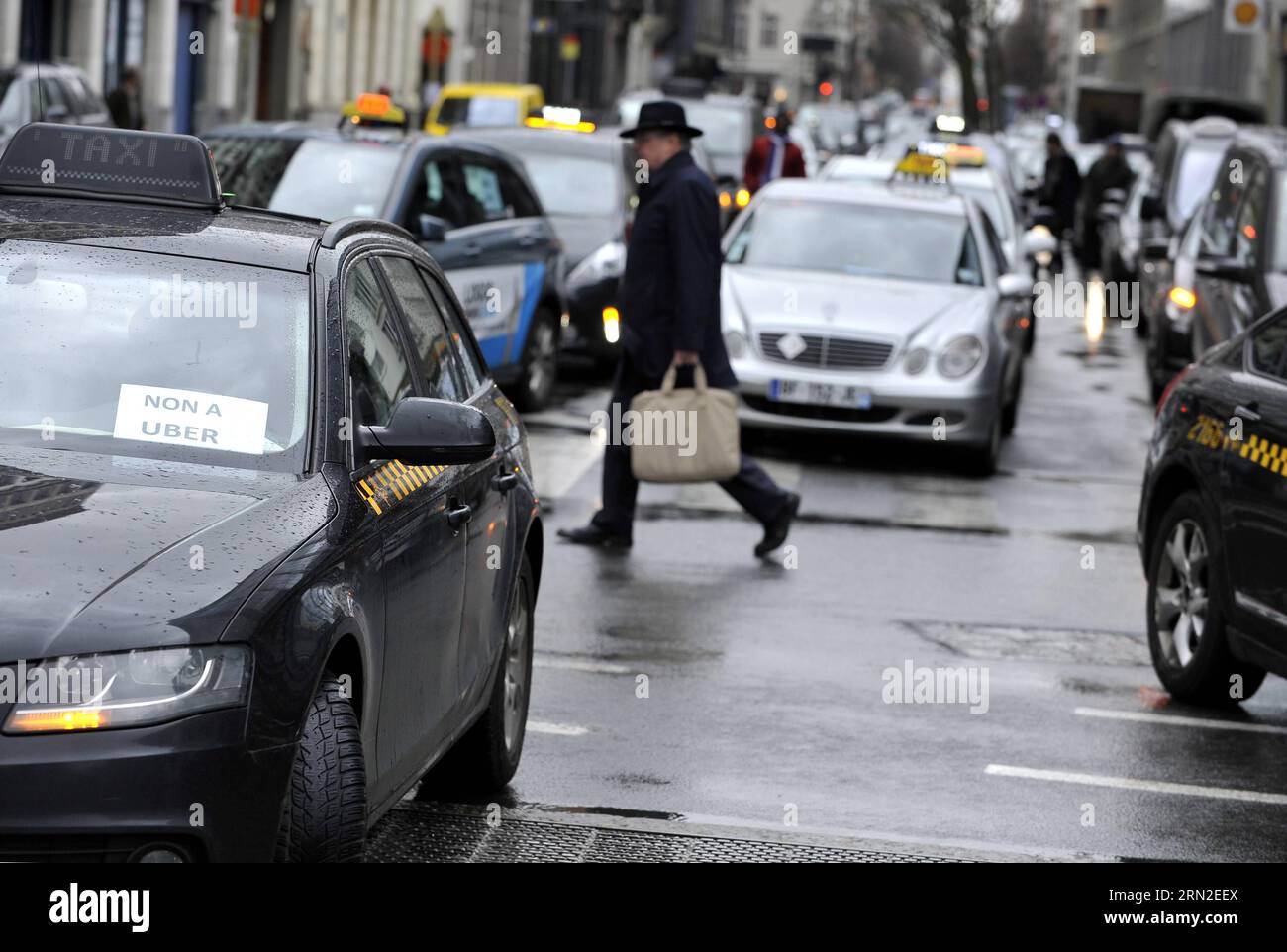 (150303) -- BRUXELLES, 3 marzo 2015 -- Una passeggiata pedonale tra i taxi in una strada di fronte al quartier generale dell'UE durante uno sciopero dei tassisti contro la società di condivisione di viaggi online Uber a Bruxelles, capitale del Belgio, 3 marzo 2015. ) BELGIO-BRUXELLES-TAXI-STRIKE YexPingfan PUBLICATIONxNOTxINxCHN Bruxelles 3 marzo 2015 un pedonale cammina tra i taxi IN una strada di fronte al quartier generale dell'UE durante un taxi Drivers Strike Against Online Ride Sharing Company sopra a Bruxelles capitale del Belgio 3 marzo 2015 Belgio Bruxelles taxi Strike PUBLICATIONxNOTxINxCHN Foto Stock