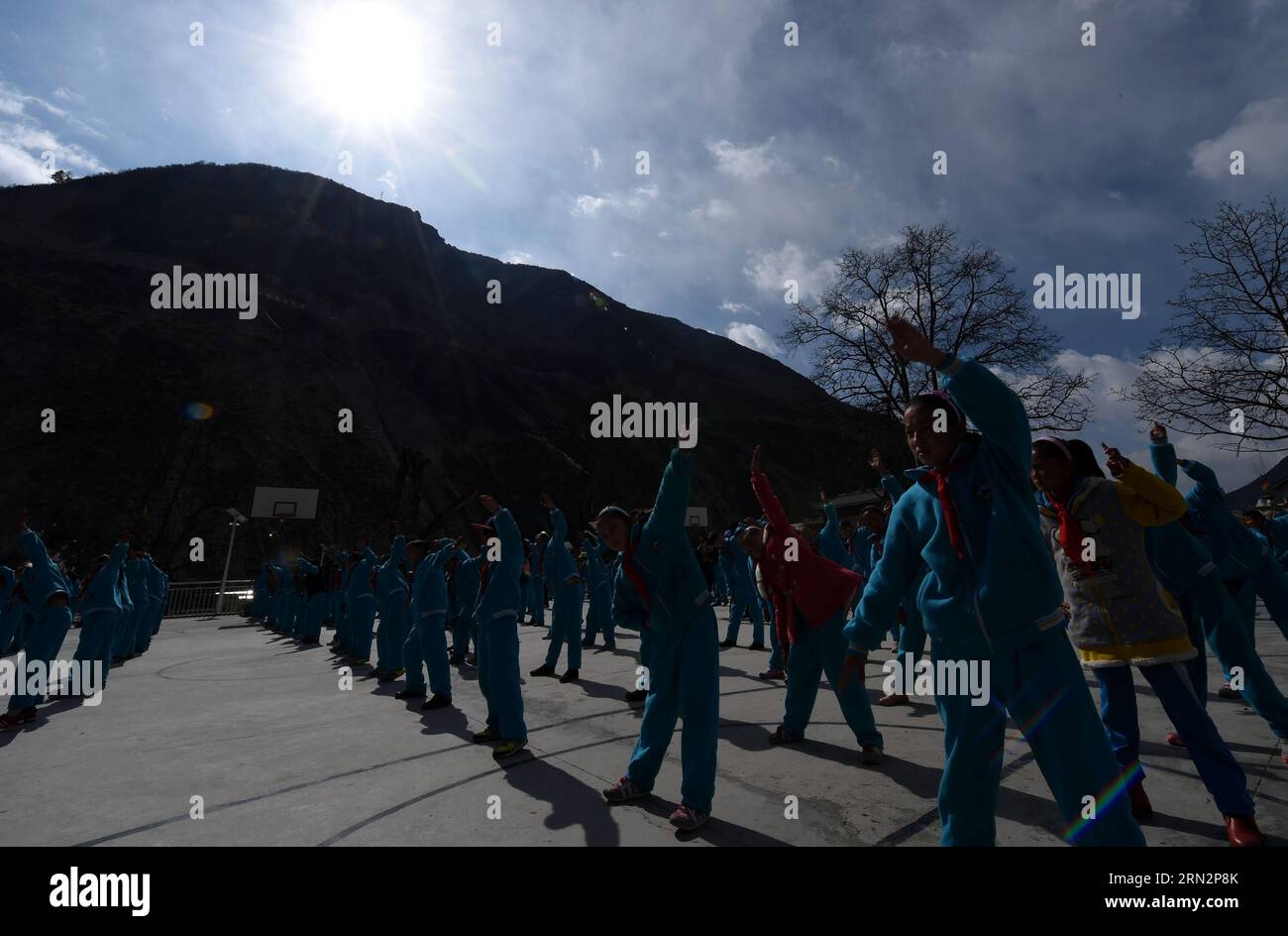 (150319) -- DEQIN, Cili Zhoima e Cili Yangzom fanno esercizi con compagni di classe presso il parco giochi della No. 1 Primary School nella contea di Deqin, Diqing nella prefettura autonoma tibetana di Diqing, nella provincia dello Yunnan della Cina sud-occidentale, 17 marzo 2015. Cili Zhoima e Cili Yangzom, sorelle gemelle del gruppo etnico tibetano, sono nate in una famiglia comune a Deqin, una bella contea situata ai piedi del monte Meili Snow, che ha un'altitudine media di 6.000 metri. Il padre apre un negozio di barbecue, mentre la madre è una contadina. Zhoima, l'anziana, ottiene buoni voti a scuola e la sua classe preferita sono gli inglesi Foto Stock