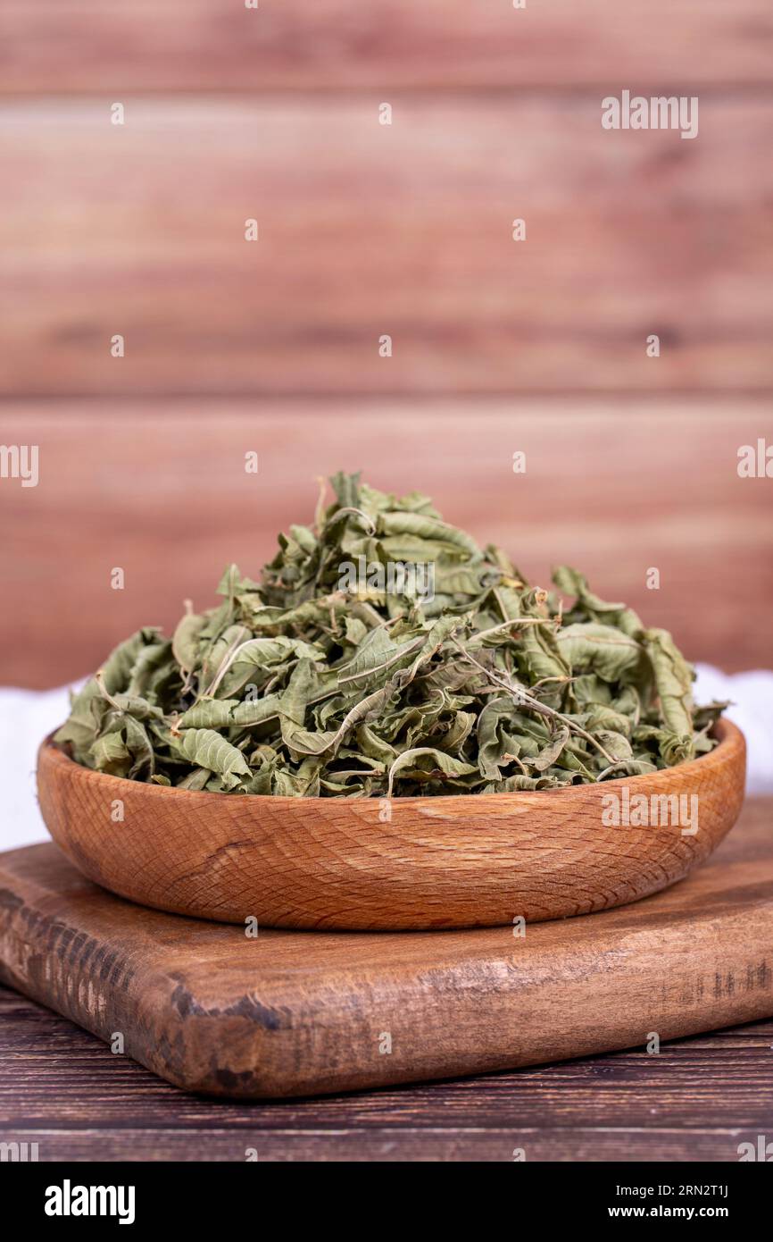 Tè di balsamo essiccato. Foglie di tè al balsamo al limone essiccate al sole in un recipiente di legno. erboristeria Foto Stock