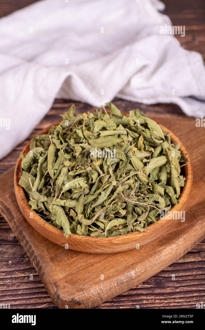 Tè di balsamo essiccato. Foglie di tè al balsamo al limone essiccate al sole in un recipiente di legno. erboristeria. Primo piano Foto Stock