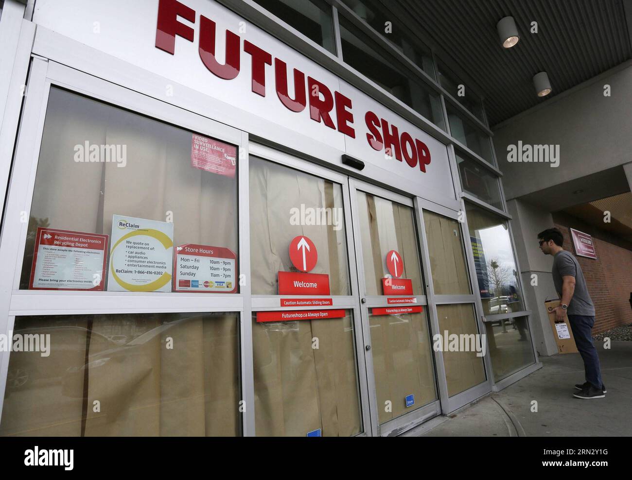 Un residente guarda l'avviso di fronte a un negozio chiuso Future Shop a Richmond, Canada, 28 marzo 2015. BEST Buy Canada Ltd. Sabato ha annunciato di aver deciso di chiudere 66 delle 131 catene di negozi di elettronica Future Shop e di consolidare il resto nel paese. In quanto più grande rivenditore canadese di computer ed elettronica di consumo, il Future Shop è stato fondato nel 1982 ed è stato acquisito dalla catena di negozi di elettronica di consumo statunitense Best Buy per 580 milioni di dollari nel novembre 2001. ) CANADA-FUTURE SHOP-CLOSE LiangxSen PUBLICATIONxNOTxINxCHN un residente esamina l'avviso davanti a un Foto Stock