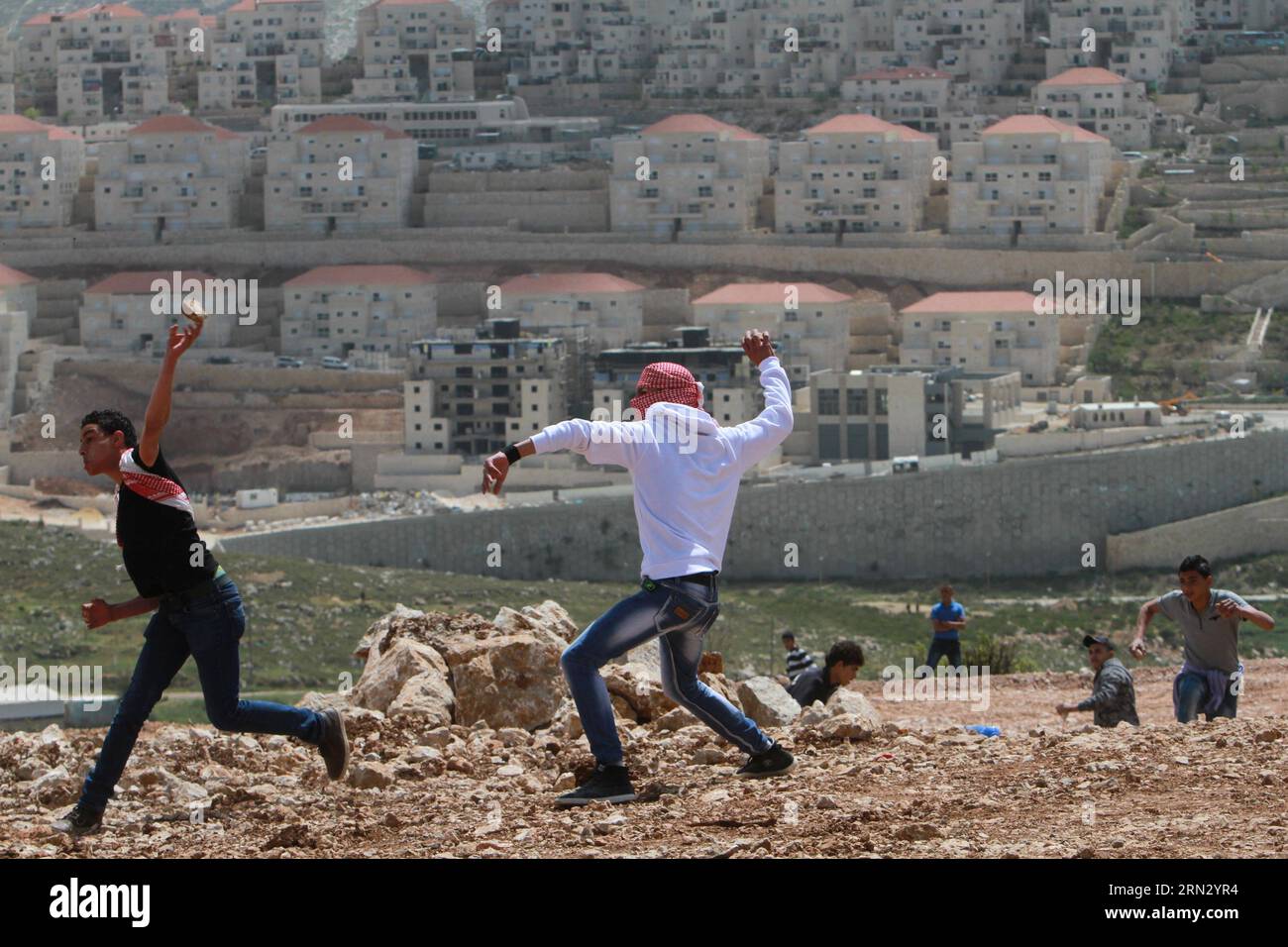 (150330) -- BETLEMME, 30 marzo 2014 -- i manifestanti palestinesi lanciano pietre contro i soldati israeliani durante una protesta che segna la giornata della Terra, nel villaggio di Wadi Fukin vicino alla città di Betlemme in Cisgiordania il prossimo marzo. 30, 2015. I palestinesi hanno celebrato la giornata della Terra il 30 marzo, la commemorazione annuale delle proteste nel 1976 contro l'appropriazione da parte di Israele di terreni di proprietà araba in Galilea. MIDEAST-BETHLEHEM-LAND-DAY-PROTESTA LuayxSababa PUBLICATIONxNOTxINxCHN Betlemme marzo 30 2014 i manifestanti PALESTINESI lanciano pietre contro i soldati israeliani durante una protesta che segna la giornata del Paese nel villaggio di Wadi vicino al CISGIORDANIA Foto Stock