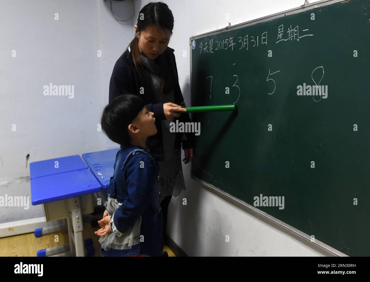 Un bambino autistico impara a distinguere le figure sotto la guida di un insegnante presso il Centro speciale di riabilitazione e formazione per bambini di Xinzhi a Changchun, capitale della provincia di Jilin della Cina nord-orientale, il 31 marzo 2015. Il 2 aprile segna l'ottava giornata Mondiale della consapevolezza dell'autismo. ) (lfj) CHINA-JILIN-WORLD AUTISM AUTISM AWARENESS DAY (CN) LinxHong PUBLICATIONxNOTxINxCHN to Autistic Child impara a distinguere le figure sotto la guida di un insegnante PRESSO IL Centro speciale di riabilitazione e formazione per bambini di Xinzhi A Changchun capitale della provincia di Jilin della Cina nordorientale il 31 2015 marzo il 2 aprile segna l'ottavo autismo mondiale Foto Stock