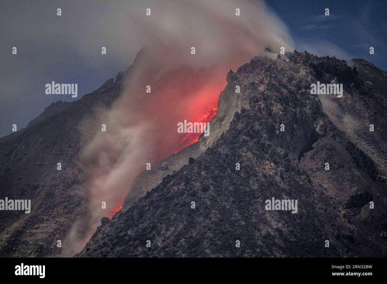 (150404) -- SUMATRA SETTENTRIONALE, 4 aprile 2015 -- la lunga fotografia di esposizione scattata prima dell'alba del 4 aprile 2015 mostra il flusso di lava bruciante e le gigantesche nubi di cenere rilasciate dal cratere durante l'eruzione del vulcano del Monte Sinabung vista dal villaggio di Kuta Tengah nel distretto di Karo, nella provincia di Sumatra settentrionale dell'Indonesia. Il vulcano del Monte Sinabung nel distretto di Karo, nella provincia di Sumatra settentrionale, è eruttato giovedì pomeriggio, sparando una colonna di cenere fino a 2 km verso il cielo e innescando un'evacuazione su piccola scala, ha detto il funzionario qui prima di venerdì. ) INDONESIA-SUMATRA SETTENTRIONALE-MONTE SINABUNG-ERUPTION TANTOX Foto Stock