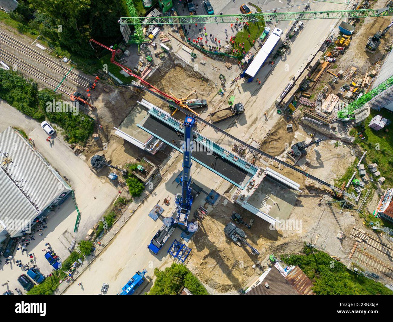 Starnberg, Germania. 31 agosto 2023. Una gru solleva un nuovo cavalcavia ferroviario sull'autostrada federale 2 a Starnberg fino alla sua fondazione. (Foto aerea scattata con un drone) il nuovo ponte avrà un'altezza di 4,5 metri e una larghezza di 26,3 metri. Due sovrastrutture in acciaio, ognuna del peso di 120 tonnellate, sono state sollevate nella loro posizione finale da una gru blu montata su autocarro da 650 tonnellate. Crediti: Peter Kneffel/dpa/Alamy Live News Foto Stock