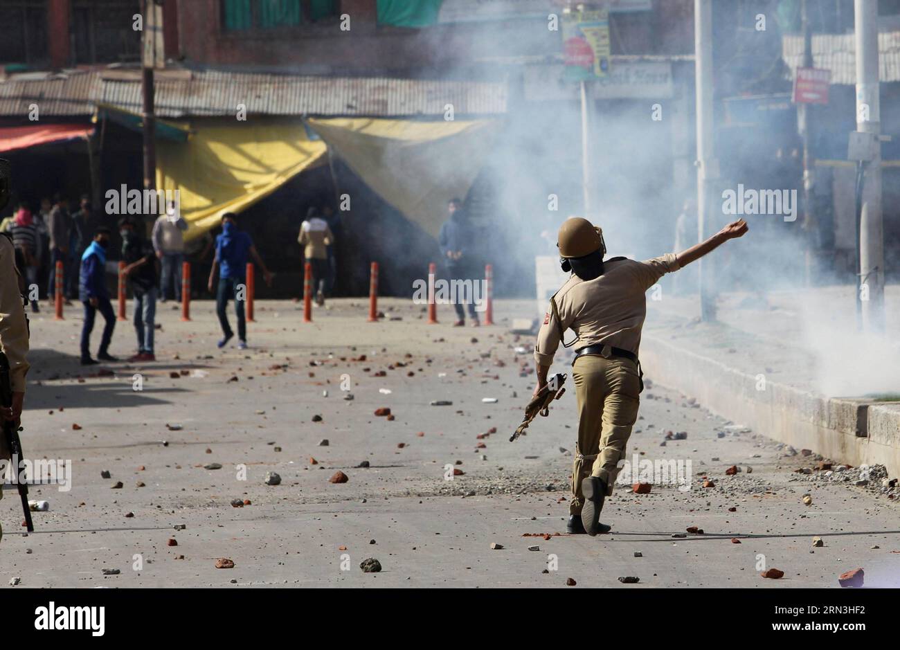 (150417) -- SRINAGAR (INDIA), 17 aprile 2015 -- un poliziotto indiano lancia pietre contro i manifestanti del Kashmir durante una protesta nella zona del centro di Srinagar, la capitale estiva del Kashmir controllato dagli indiani, 17 aprile 2015. Venerdì le forze governative nel Kashmir controllato dagli indiani hanno sparato colpi di avvertimento e decine di proiettili fumogeni lacrimogeni per disperdere centinaia di manifestanti irati che manifestano contro la repressione dei separatisti in vista di una manifestazione per piangere l'uccisione di un giovane. ) INDIA-KASHMIR-SRINAGAR-PROTESTA-SCONTRI JavedxDar PUBLICATIONxNOTxINxCHN Srinagar India 17 aprile 2015 al poliziotto indiano lancia pietra Foto Stock