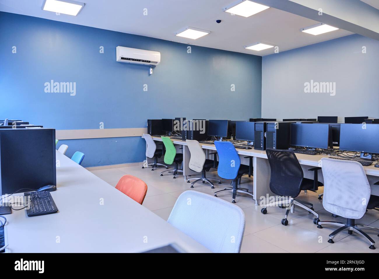 un laboratorio informatico vuoto in un'università. Sala di laboratorio per computer. camera con molti computer, scrivanie, sedie e tastiere. Foto Stock