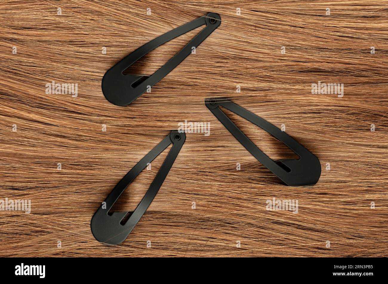 Gruppo di clip di capelli neri su sfondo rosso Foto Stock