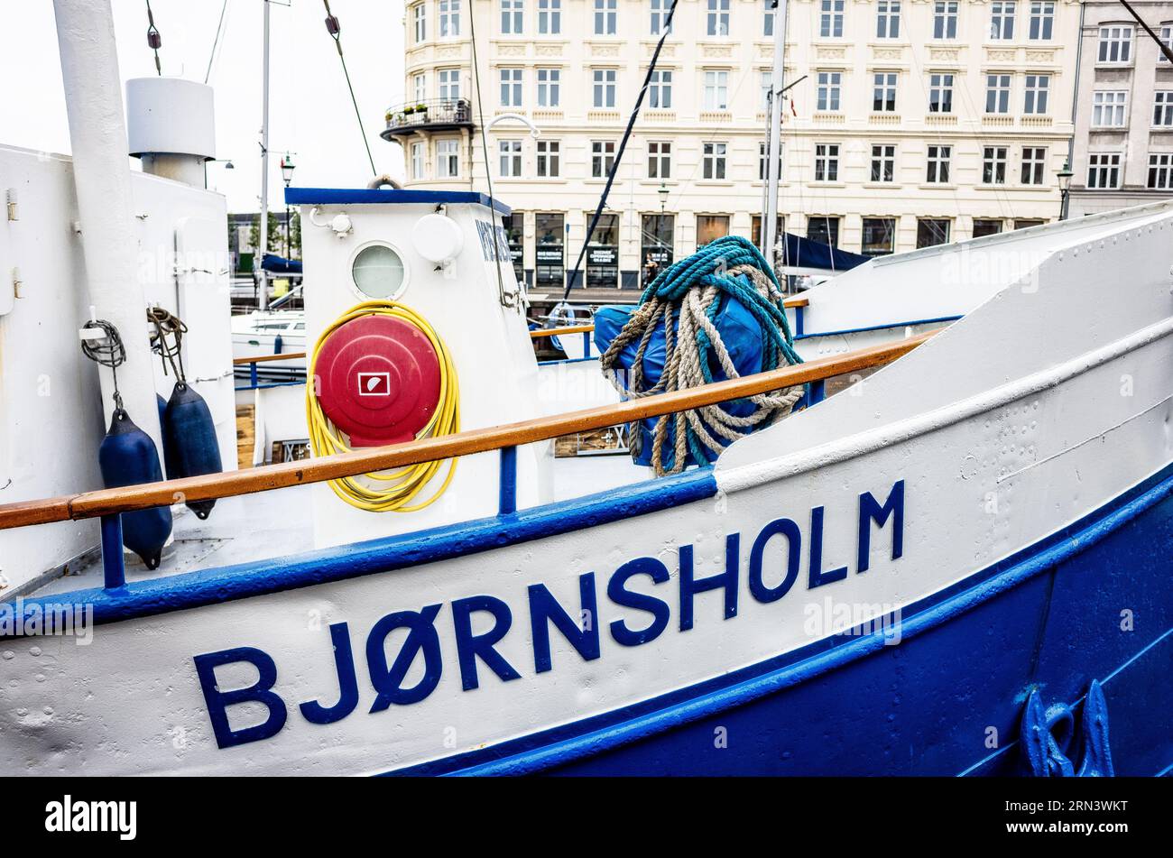 COPENAGHEN, Danimarca — la nave Bjornsholm attraccata a Nyhavn. Nyhavn, lo storico porto di Copenaghen, è visto animato da attività. Un tempo porto commerciale dove attraccavano navi da tutto il mondo, Nyhavn è ora un luogo di ritrovo culturale pieno di ristoranti, bar e case tradizionali, segnando la sua trasformazione da vivace centro marittimo a principale attrazione turistica. Foto Stock