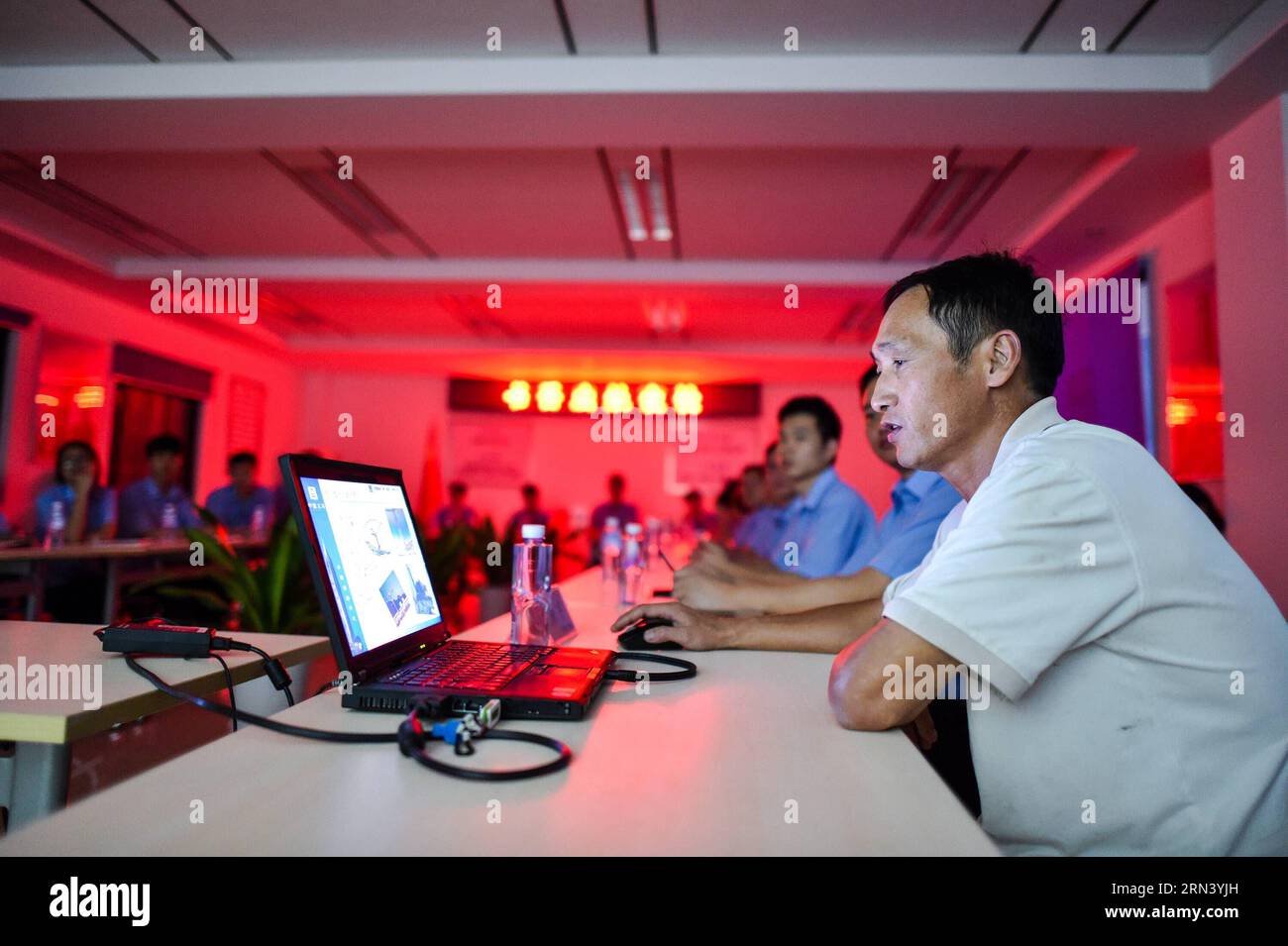 (150430) - SHENZHEN, 30 aprile 2015 - foto scattata il 16 aprile 2015 mostra Wang Hua, un operatore di gru a torre, insegna ai giovani colleghi della gru a torre nella sua azienda a Shenzhen, nella provincia del Guangdong nella Cina meridionale. Wang Hua, 50 anni della provincia di Henan, è una buona persona nella gru a torre operativa. Anche se era una guardia di sicurezza quando era giovane, è diventato rapidamente un eccellente operatore di gru a torre grazie alla sua diligenza e al suo amore per l'apprendimento. È stato impegnato in molti progetti di costruzione più grandi come il nuovo sito di CCTV e il Water Cube, e il progetto attuale è Wor Foto Stock