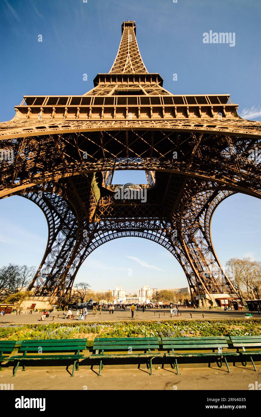 Vista della base della Torre Eiffel Parigi Francia // PARIGI, Francia - la Torre Eiffel si innalza nel cielo, vista dalla sua base in una giornata di sole. L'iconica struttura a reticolo in ferro battuto, simbolo di Parigi, si estende verso l'alto, mostrando il suo complesso design architettonico. Foto Stock