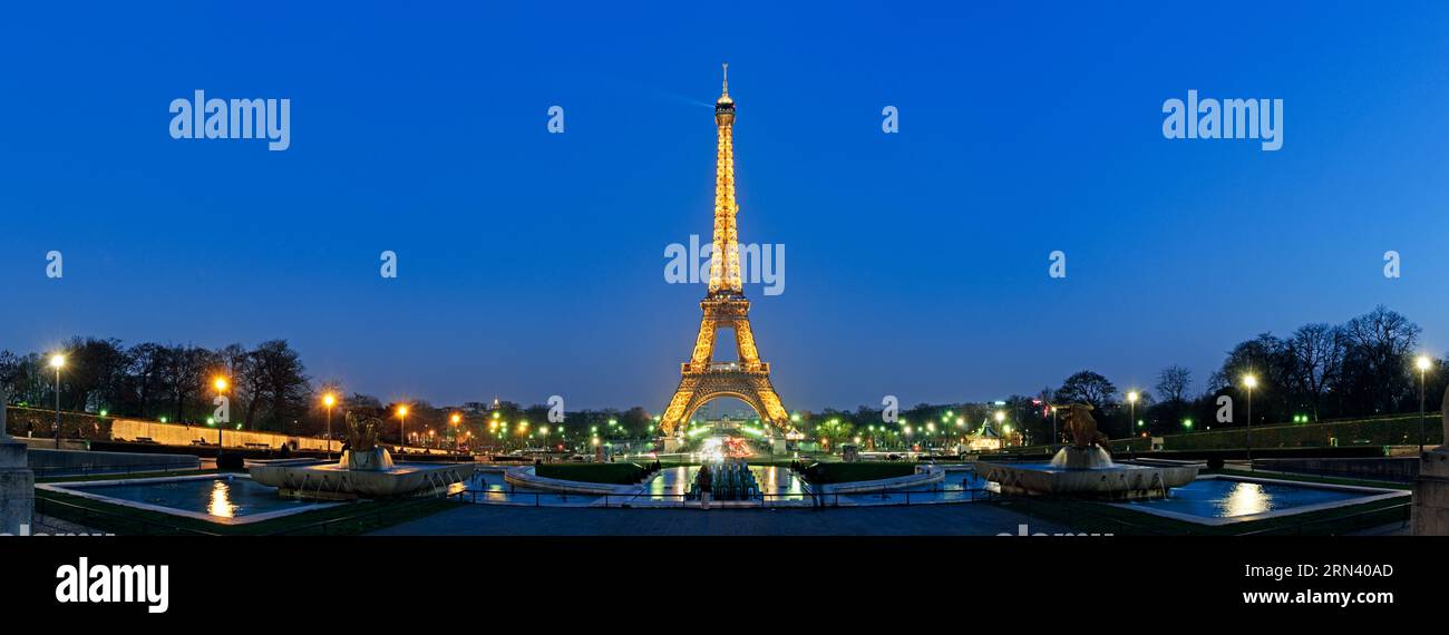 Torre Eiffel illuminata di notte Parigi Francia // PARIGI, Francia - la Torre Eiffel è illuminata contro il cielo serale in questa foto panoramica ad alta risoluzione della capitale francese. La torre di ferro, completata nel 1889 per l'esposizione universale, fu progettata dall'ingegnere Gustave Eiffel e originariamente serviva come arco d'ingresso alla fiera mondiale. Con un'altezza di 330 metri (1.083 piedi), la struttura fu inizialmente concepita come installazione temporanea, ma divenne un simbolo permanente di Parigi. La torre si trova sul campo di Marte nel settimo arrondissement e attira milioni di persone Foto Stock