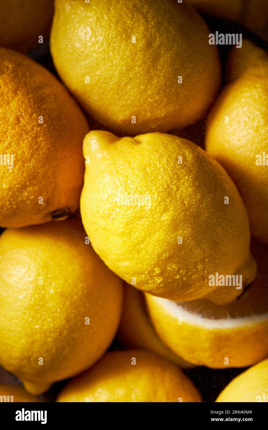 Immagine dall'alto di molti limoni che riempiono lo shot. Colore giallo brillante ad alto contrasto. Ottima consistenza degli agrumi. Immagine verticale. Foto Stock