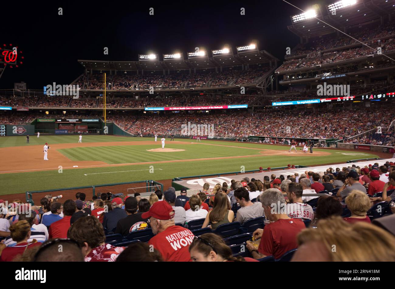 Nationals Park Baseball Game Washington D.C. // WASHINGTON D.C., Stati Uniti — Una partita di baseball notturna al Nationals Park ospita i Washington Nationals che affrontano gli Arizona Diamondbacks. Il campo luminoso contrasta con il cielo scuro, creando un'atmosfera vibrante mentre giocatori e tifosi si impegnano nel passatempo americano. Foto Stock