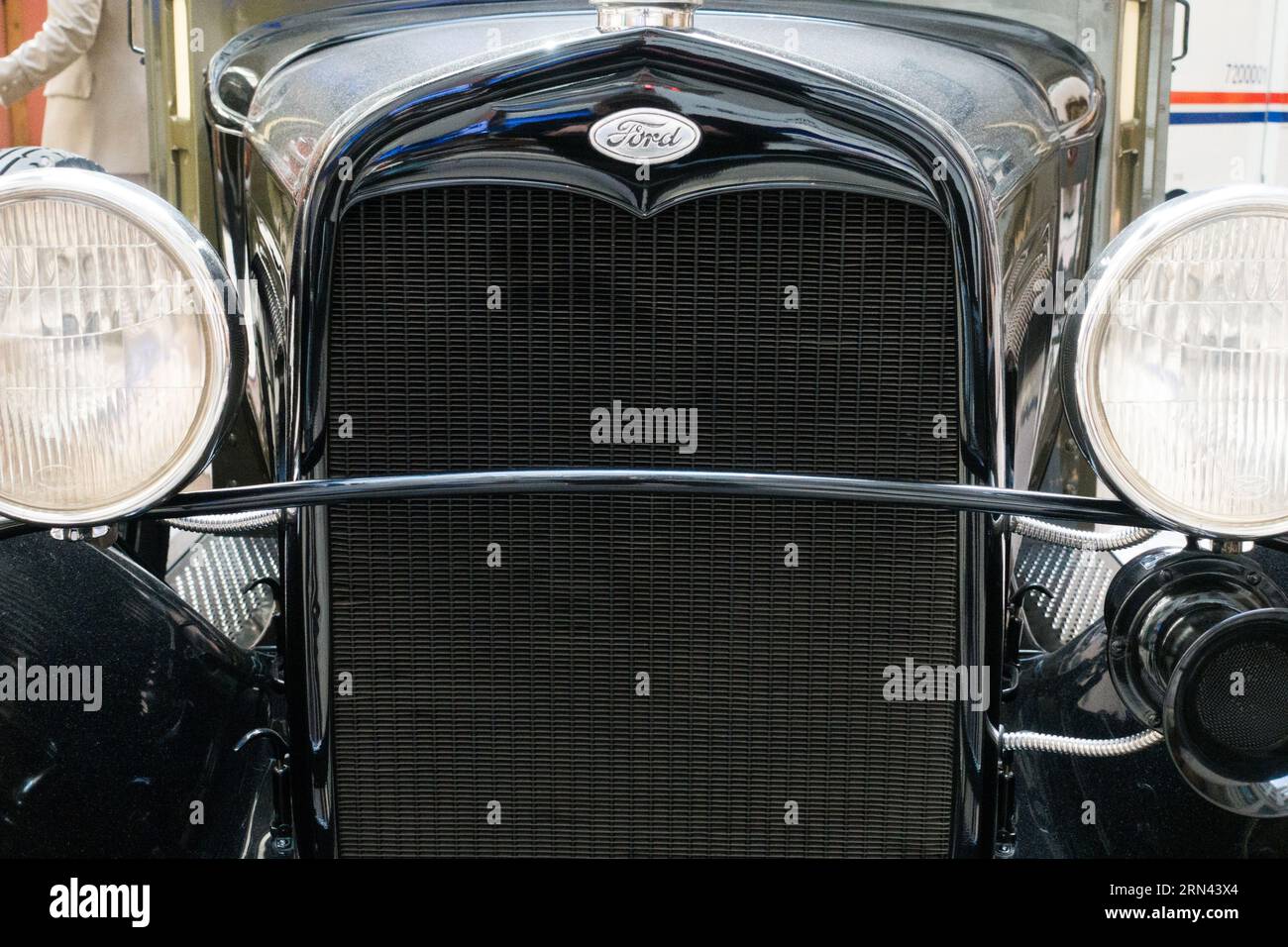 Ford Vintage Car Radiator Grill fari // DSC-RX100M5 | lunghezza focale (equiv. 35 mm): 52 mm | velocità dell'otturatore: ¹⁄₆₀ sec | apertura: ƒ / 4,5 | ISO 3200 | bias esposizione: - 1 ³⁄₁₀ EV Foto Stock