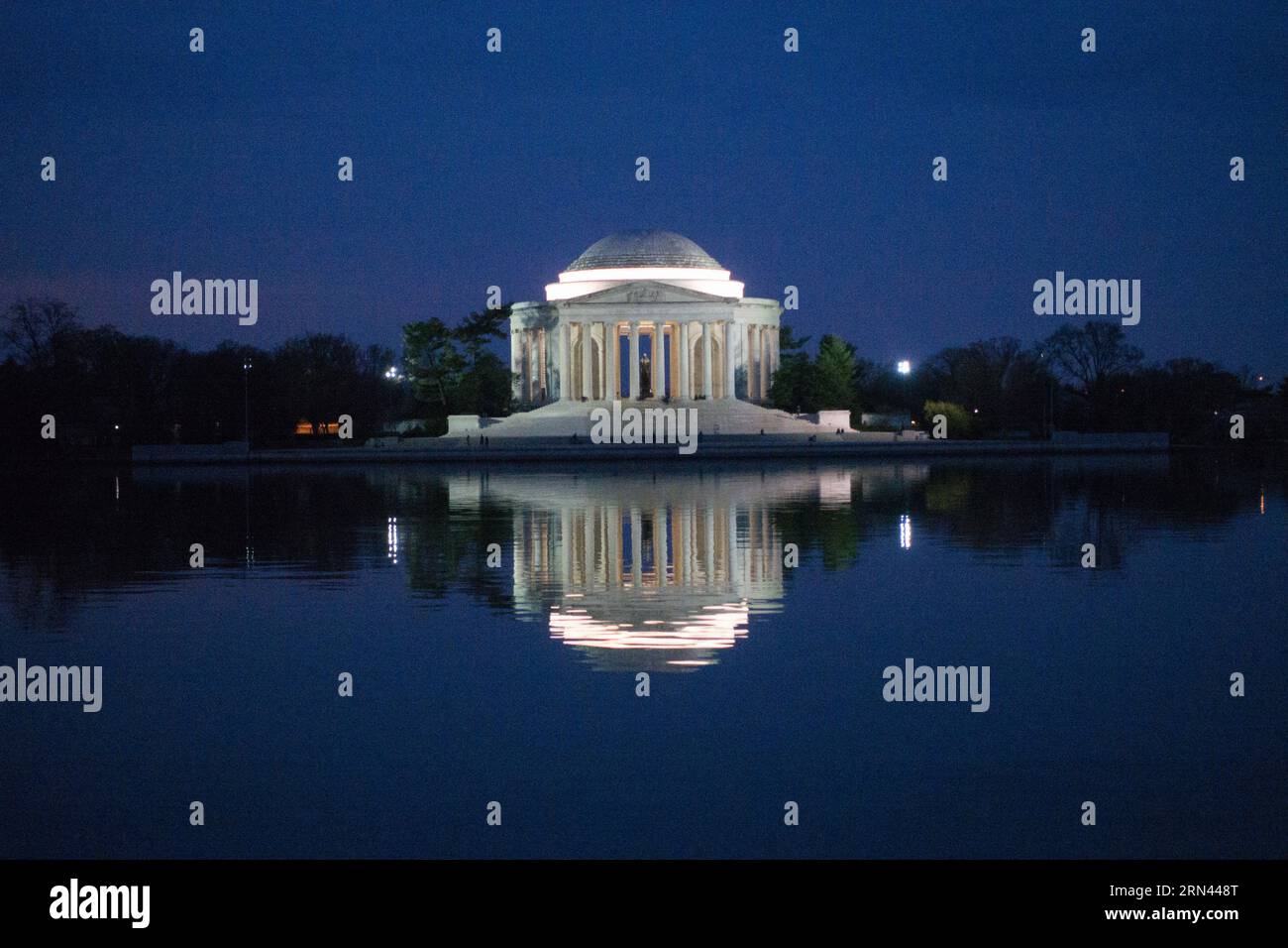 Thomas Jefferson Memorial Reflection at Night Washington DC // WASHINGTON, D.C., Stati Uniti — il Thomas Jefferson Memorial si riflette nelle acque calme del bacino delle maree di notte. Il monumento neoclassico, dedicato al terzo presidente degli Stati Uniti, è illuminato contro il cielo scuro. La struttura a cupola e la sua immagine speculare creano una scena simmetrica sul National Mall. Foto Stock