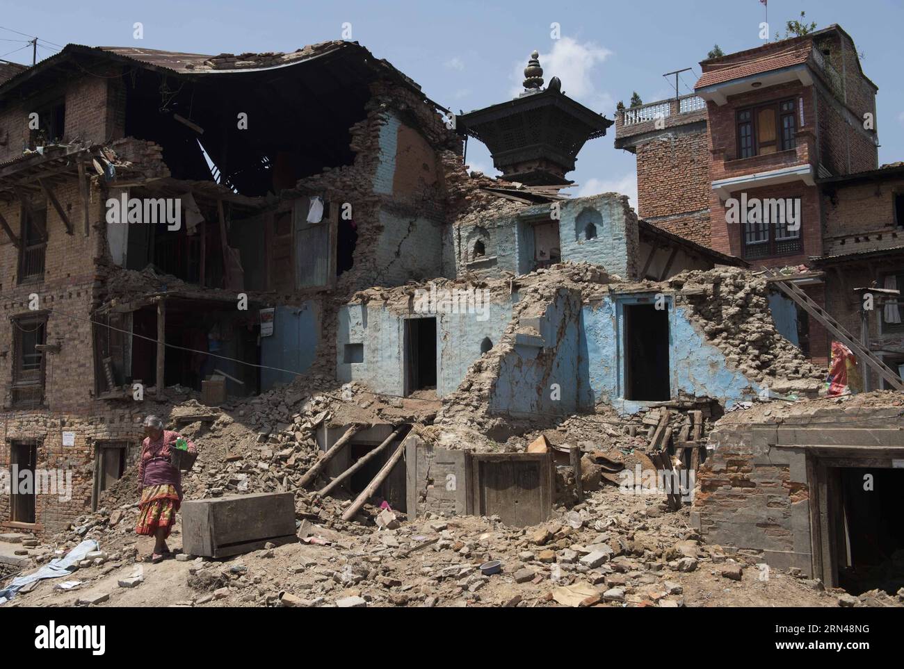 (150512) -- LALITPUR, 12 maggio 2015 -- una vecchia signora cammina davanti agli edifici danneggiati a Lalitpur, un'antica città adiacente a Kathmandu, capitale del Nepal, il 12 maggio 2015. Lalitpur è stata gravemente danneggiata nel terremoto del mese scorso e in seguito alle scosse. NEPAL-LALITPUR-EARTH QUAKE-DAMAGE LuixSiuxwai PUBLICATIONxNOTxINxCHN 150512 Lalitpur 12 maggio 2015 a Old Lady Walks di fronte agli edifici danneggiati di Lalitpur nella città antica adiacente a Kathmandu capitale del Nepal IL 12 maggio 2015 Lalitpur cosa ha danneggiato GRAVEMENTE Il terremoto del mese di carico e dopo scosse EGP Nepal Lalitpur Ear Foto Stock