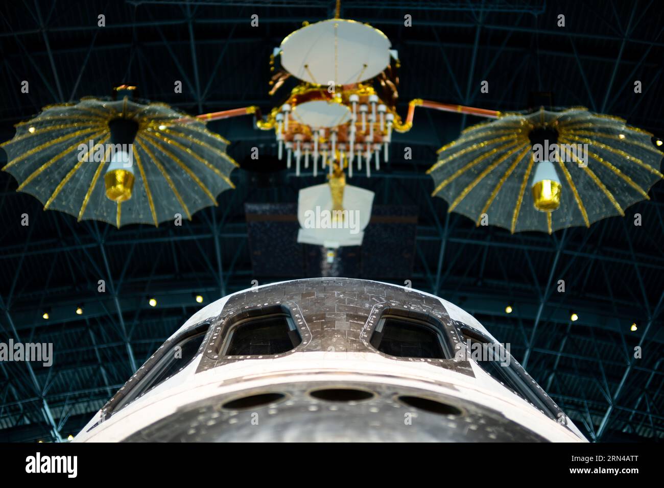 Steven F Udvar Hazy Center TDRS modello Chantilly Virginia | CHANTILLY, Virginia - Un modello di un satellite di tracciamento e trasmissione dati appeso sopra la cabina di pilotaggio dello Space Shuttle Discovery nel James S. McDonnell Space Hangar presso lo Steven F. Udvar-Hazy Center. La costellazione TDRS, dispiegata a partire dal 1983, diede alla NASA una comunicazione quasi continua con veicoli spaziali orbitanti, sostituendo una costosa rete di stazioni terrestri. Il modello di 4,3 m fu costruito dalla Design Models, Inc. Sotto la direzione di TRW e donato al museo nel 1986. Foto Stock