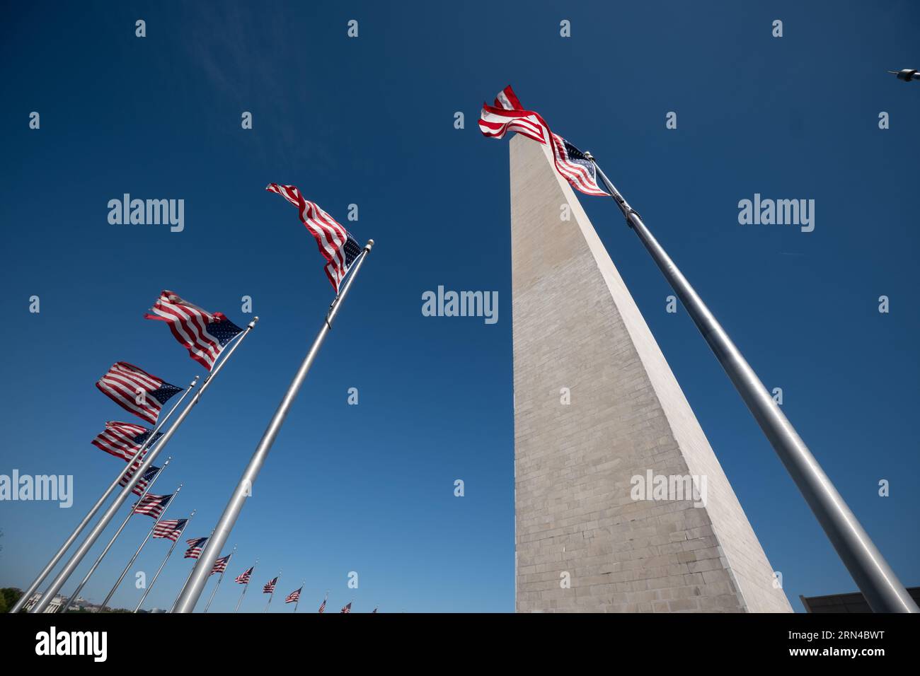 WASHINGTON, DC - torreggiante a 554 metri sopra il National Mall di Washington DC, il Washington Monument commemora George Washington, il primo presidente degli Stati Uniti. Dopo un progetto di costruzione decennale, fu completato nel 1884. Ha la forma di un obelisco in stile egiziano e le sue spesse pareti di marmo racchiudono un ascensore e una lunga scala a chiocciola che fornisce accesso a piccole camere in cima. Cinquanta bandiere americane suonano la sua base. Foto Stock