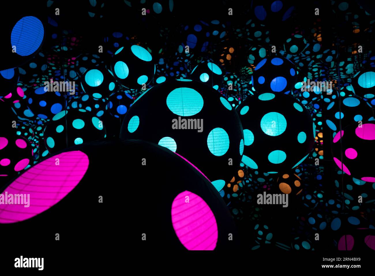 Yayoi Kusama Infinity Room Hirshhorn Museum Washington DC | WASHINGTON D.C., Stati Uniti - file di lanterne a pois scintillanti si moltiplicano per infinito all'interno di una sala a specchio Yayoi Kusama Infinity presso il Museo Hirshhorn. L'installazione, parte di "One with Eternity", abbina pareti a specchio con sfere illuminate per dissolvere i confini della stanza fisica, un segno distintivo della decennale esplorazione di pattern e spazio dell'artista giapponese. Foto Stock