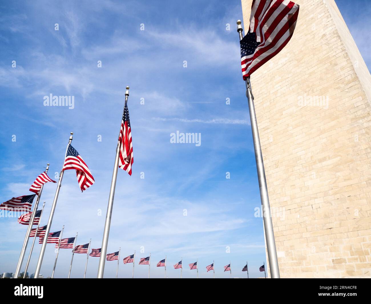 Washington Monument American Flags Washington DC // WASHINGTON DC - alto 554 metri sopra il National Mall di Washington DC, il Washington Monument commemora George Washington, il primo presidente degli Stati Uniti. Dopo un progetto di costruzione lungo decenni, è stato completato nel 1884. È stato modellato come un obelisco in stile egiziano e le sue spesse pareti di marmo racchiudono un ascensore e una lunga scala a chiocciola che fornisce l'accesso alle piccole camere in cima. Cinquanta bandiere americane suonano la sua base. Foto Stock