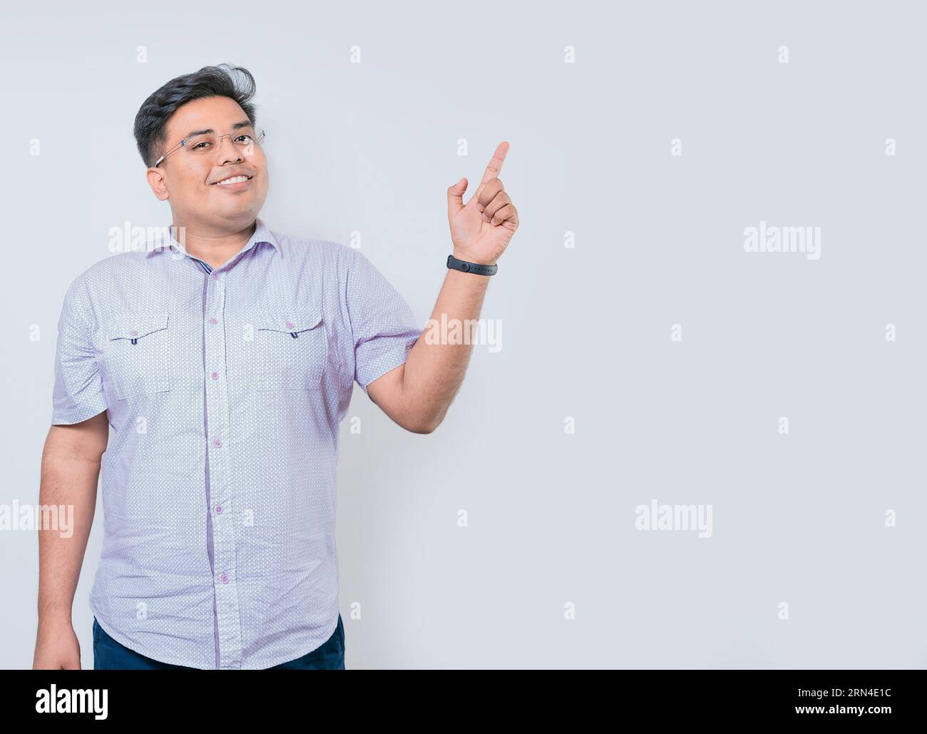 Felice uomo latino che indica uno spazio da un lato isolato. Persone sorridenti che puntano uno striscione di lato Foto Stock