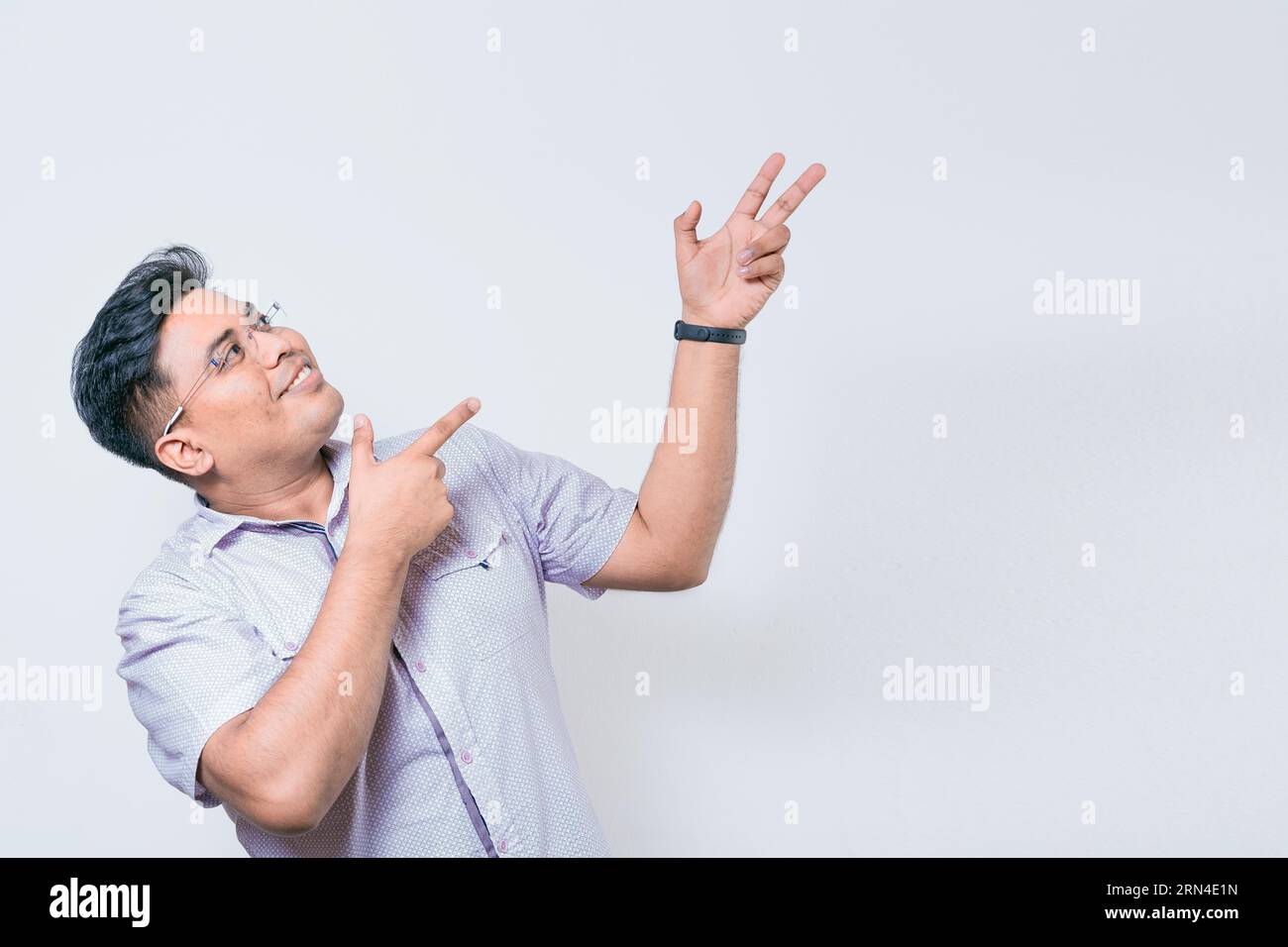 Persone sorridenti che puntano uno striscione di lato. Felice uomo latino che indica la pubblicità, sorridente uomo con gli occhiali che punta uno spazio di lato Foto Stock