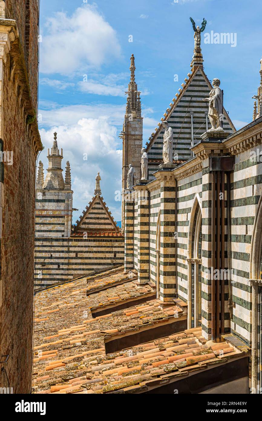 Sul tetto della cattedrale con la sua facciata in marmo a righe bianche e nere, Siena, Toscana, Italia, Europa Foto Stock