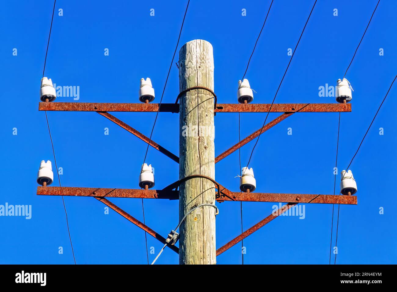 Vecchio palo telefonico con isolanti in porcellana e cavo telefonico in un cielo blu, Svezia Foto Stock