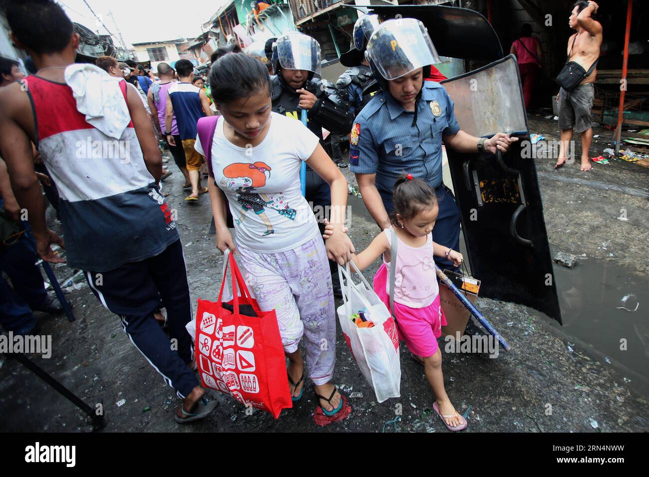 AKTUELLES ZEITGESCHEHEN Philippinen: Ausschreitungen bei Räumung und Abriss eines Armenviertels (150526) -- CALOOCAN CITY, 26 maggio 2015 -- Un poliziotto aiuta una donna e una ragazza mentre le squadre di demolizione smantellano le baraccopoli a Caloocan City, Filippine, 26 maggio 2015. Quattro persone sono rimaste ferite mentre altre due sono state arrestate dopo che i residenti si sono scontrati con le autorità. 500 famiglie sono state lasciate senza tetto nella demolizione della zona baraccopoli. ) FILIPPINE-CALOOCAN CITY-SLUM AREA DEMOLITION RouellexUmali PUBLICATIONxNOTxINxCHN News eventi attuali Filippine Riots at Clearance and Demolition a Poor di Foto Stock