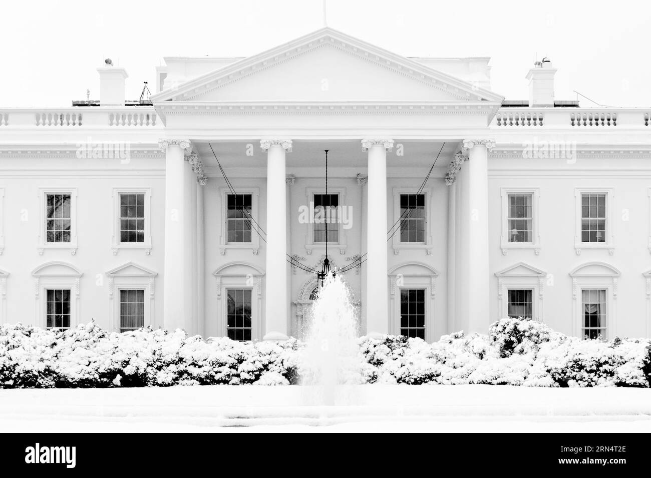 White House in Snow, Washington, D.C. Fotografia in bianco e nero che mostra la facciata dell'edificio e una fontana in primo piano. Foto Stock