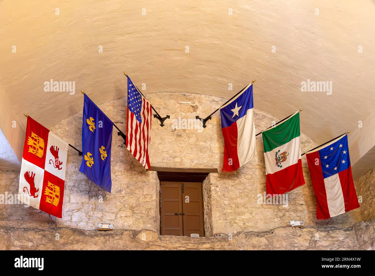 San Antonio, Texas, Stati Uniti d'America – 7 maggio 2023: Interno dell'Alamo a San Antonio con una mostra delle sei storiche bandiere del Texas. Foto Stock