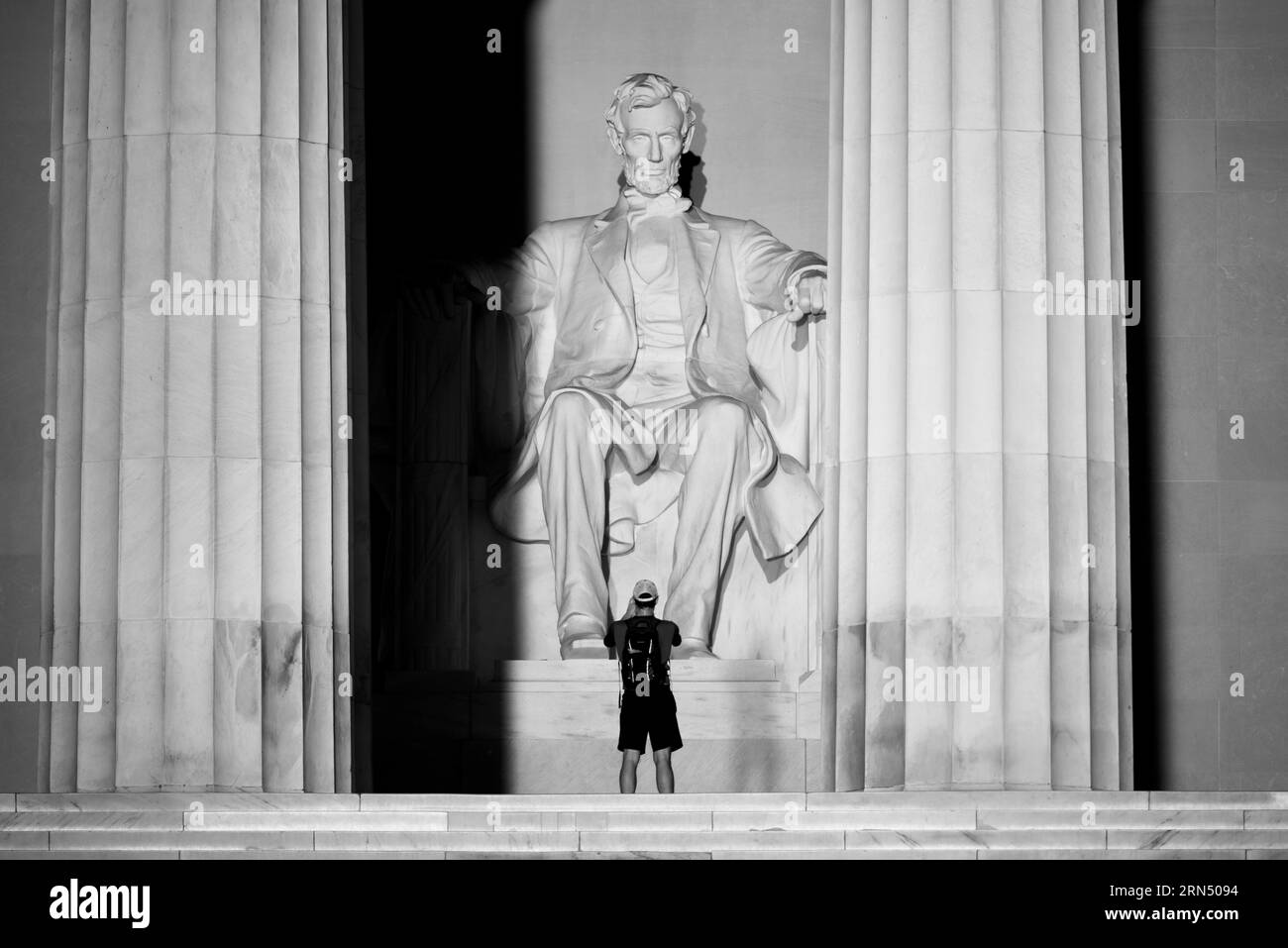 Statua di Abraham Lincoln, Lincoln Memorial, Washington. Fotografia in bianco e nero che mostra un visitatore in piedi davanti alla statua e alle colonne neoclassiche. Foto Stock