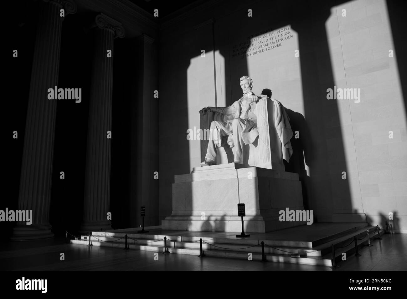 Statua di Abraham Lincoln, Washington, D.C. Fotografia in bianco e nero che mostra la statua all'interno del Lincoln Memorial con fasci di luce che brillano su di essa. Foto Stock