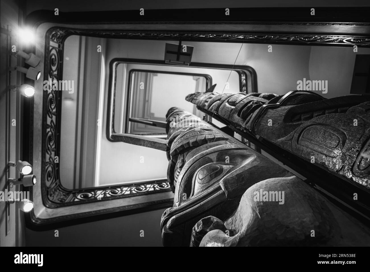 Tsimshian Totem Pole, Smithsonian Natural History Museum, Washington D.C. Fotografia in bianco e nero scattata da un'angolazione bassa, che mostra i dettagli scolpiti del totem contro l'architettura del museo. Foto Stock