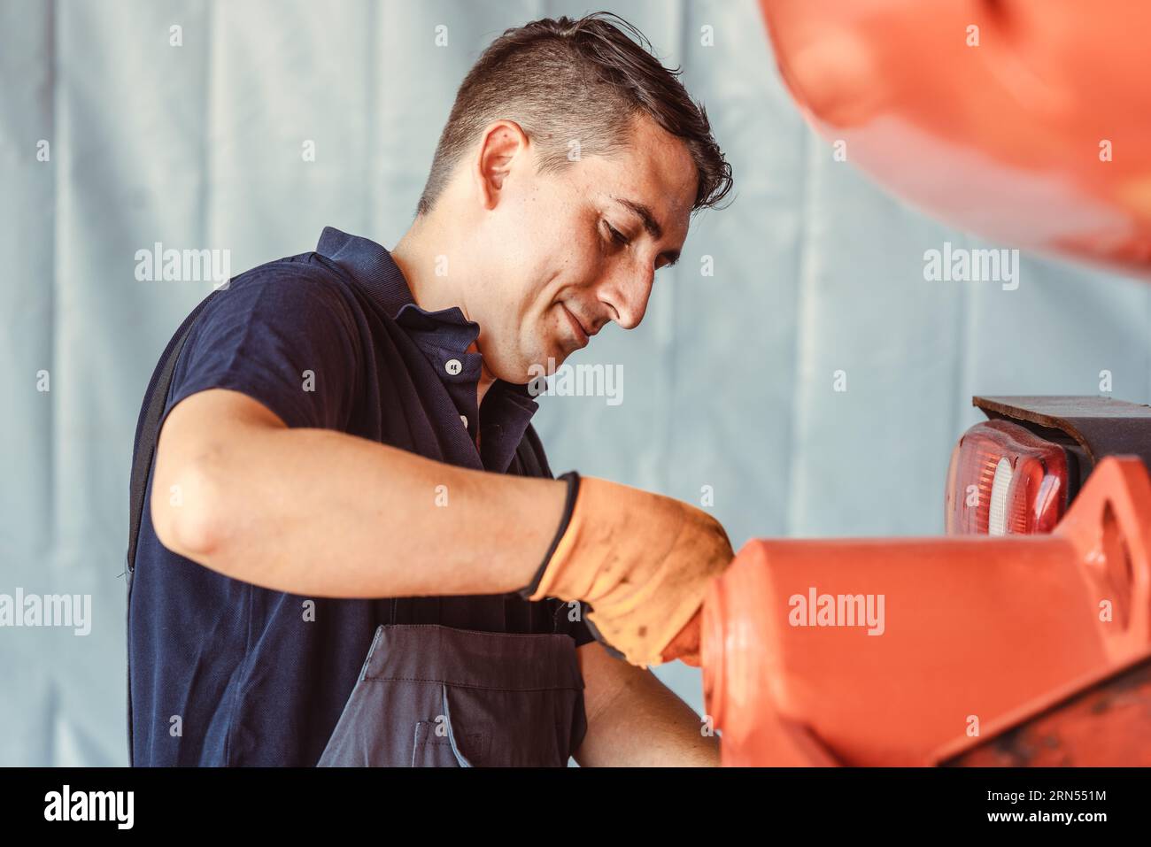 Tecnico per macchine agricole che esegue lavori di manutenzione Foto Stock