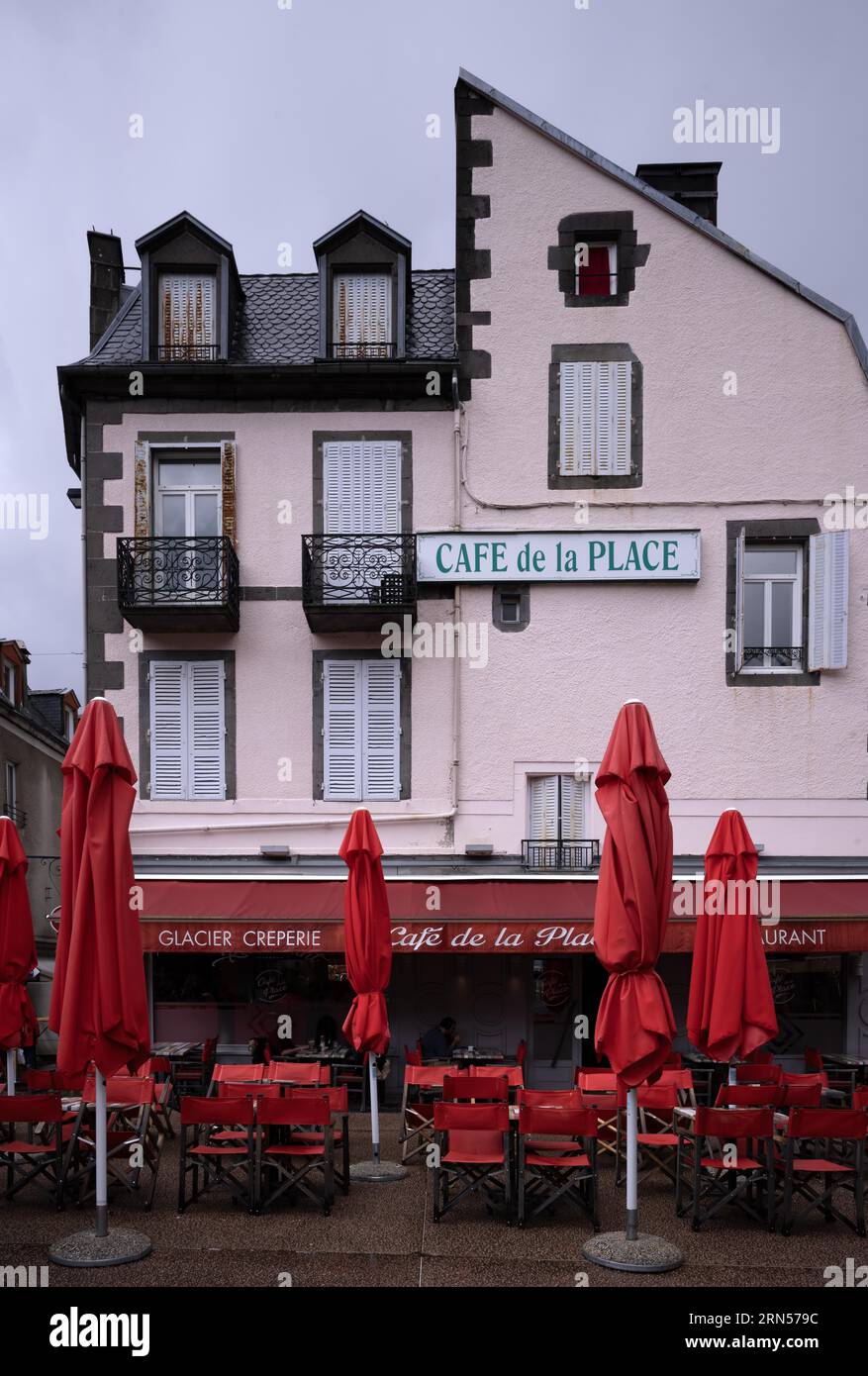 Café de la Place sotto la pioggia, piovoso, ombrelloni chiusi, rosso, Mont-Dore, dipartimento Puy-de-Dome, regione Auvergne-Rhône-Alpes, Francia, Europa Foto Stock