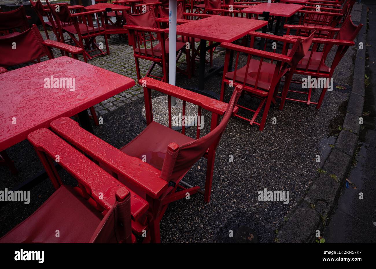 Cafe de la Place sotto la pioggia, piovoso, tavoli vuoti, rosso, Mont-Dore, dipartimento di Puy-de-Dome, regione Auvergne-Rodano-Alpes, Francia Foto Stock