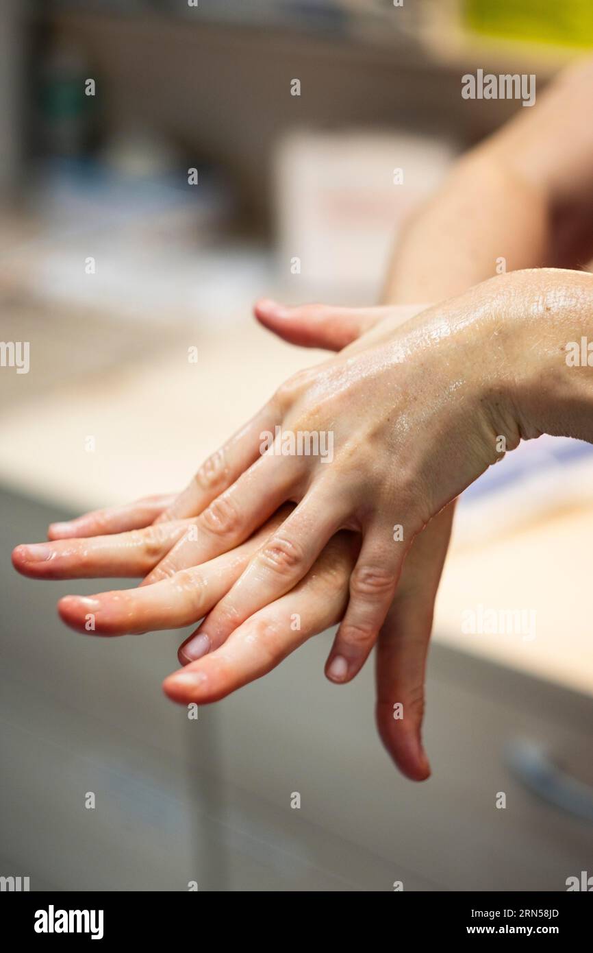 Un medico si prepara per un'operazione e sterilizza le mani con un disinfettante Foto Stock