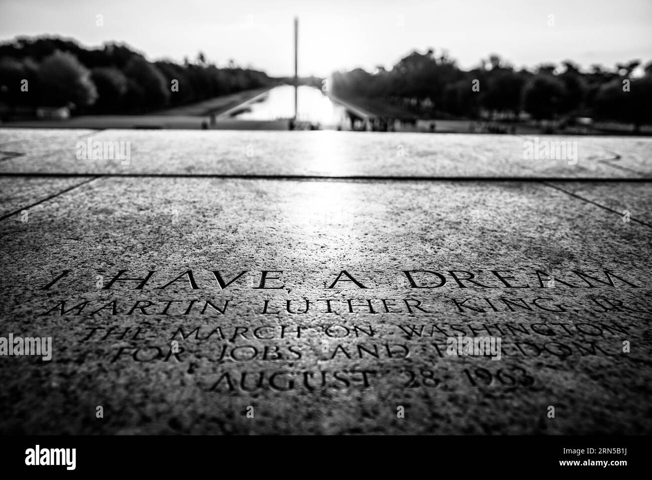 Targa Martin Luther King Jr., Lincoln Memorial, Washington, D.C. Fotografia in bianco e nero che mostra il marcatore in pietra incisa con la piscina riflettente e il monumento a Washington sullo sfondo. Foto Stock