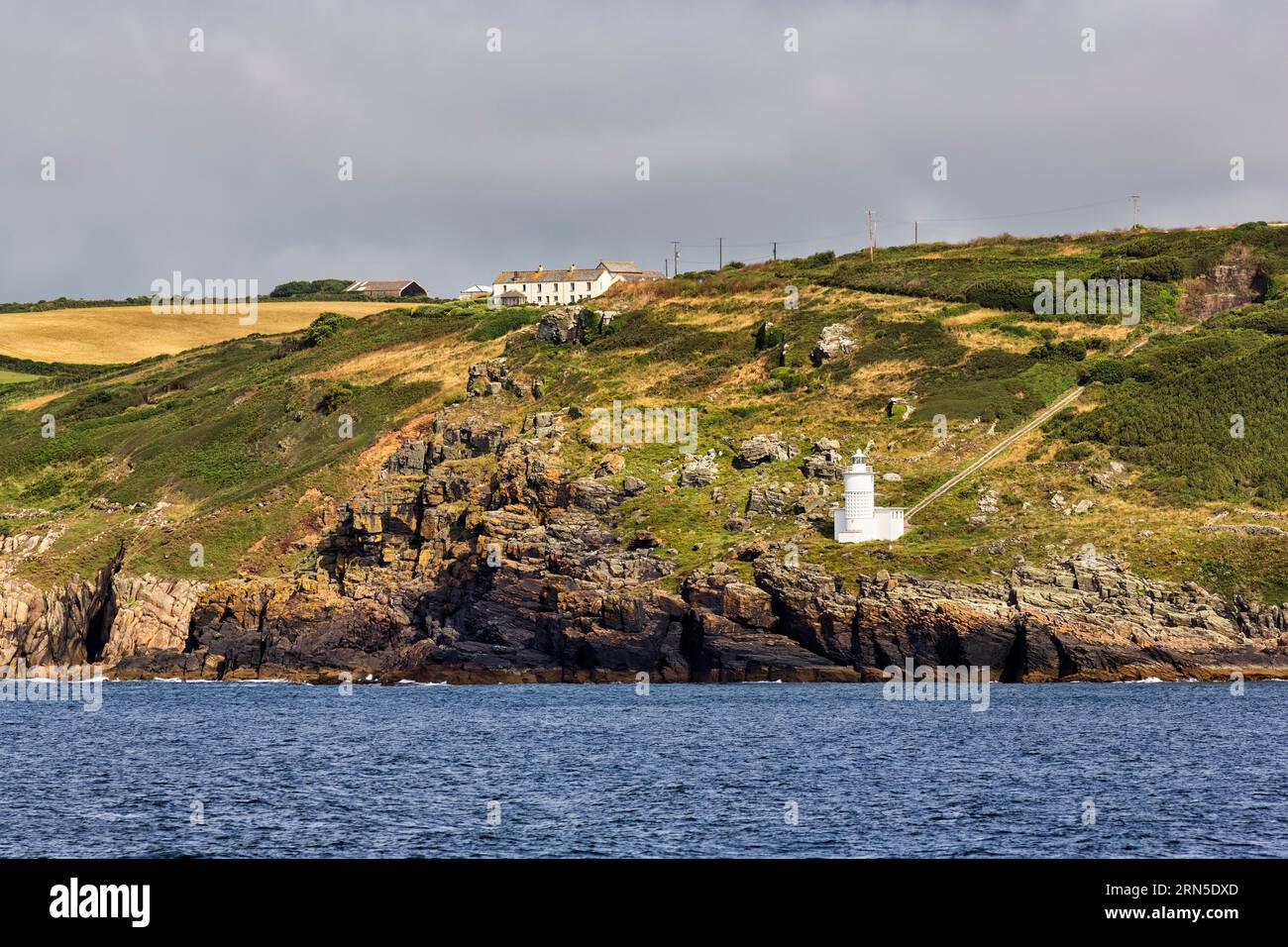 Tater-du Lighthouse sulla costa rocciosa, Penzance, Cornovaglia, Inghilterra, Regno Unito Foto Stock