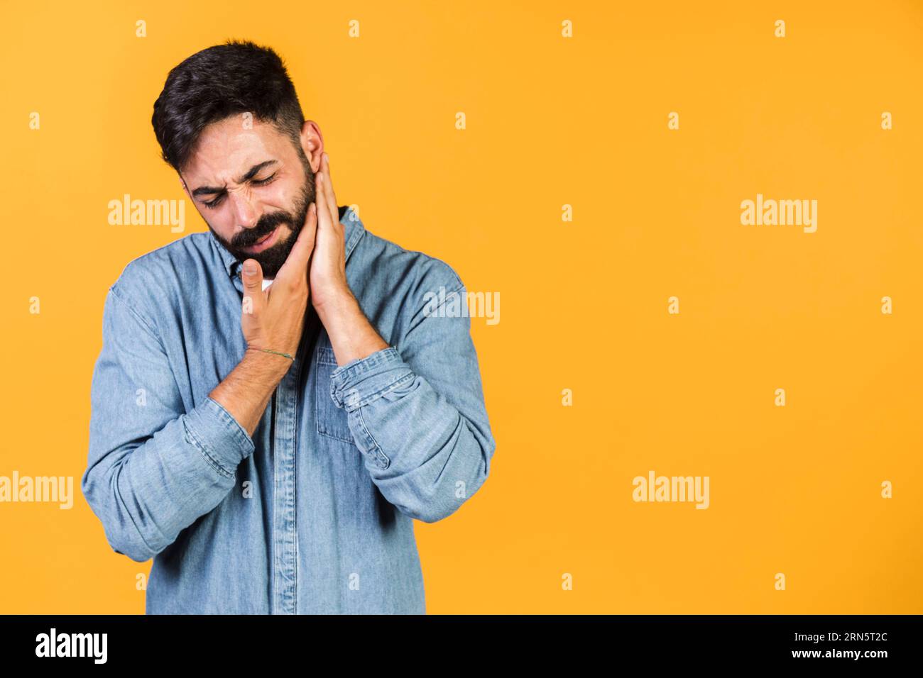 Tira il ragazzo medio con le mani il suo mento Foto Stock