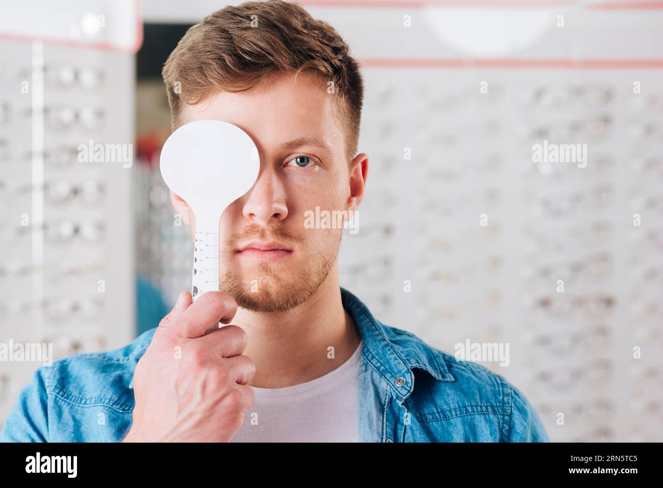 Uomo ritratto che fa una visione di prova dell'occhio Foto Stock