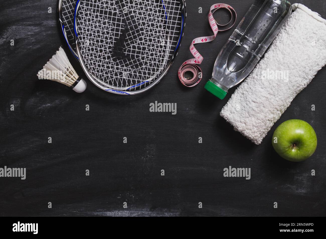 Composizione con bottiglia d'acqua di badminton mela Foto Stock